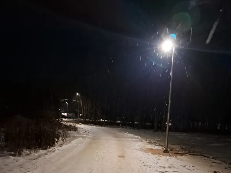 Uus välisvalgusti öösel lumise tee ääres Kakumetsa külas